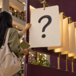 A learner turns a question card in a library, representing step-by-step study with AI.